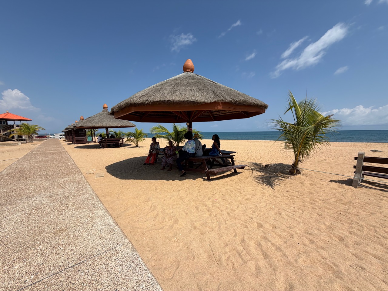 Travelers relaxing beneath a shaded beach pavilion on a previous Ghana journey